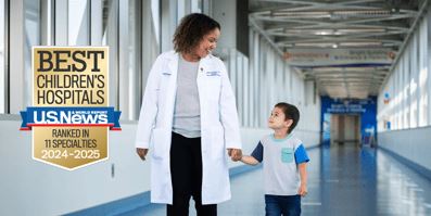 Physician holding little boys hand.